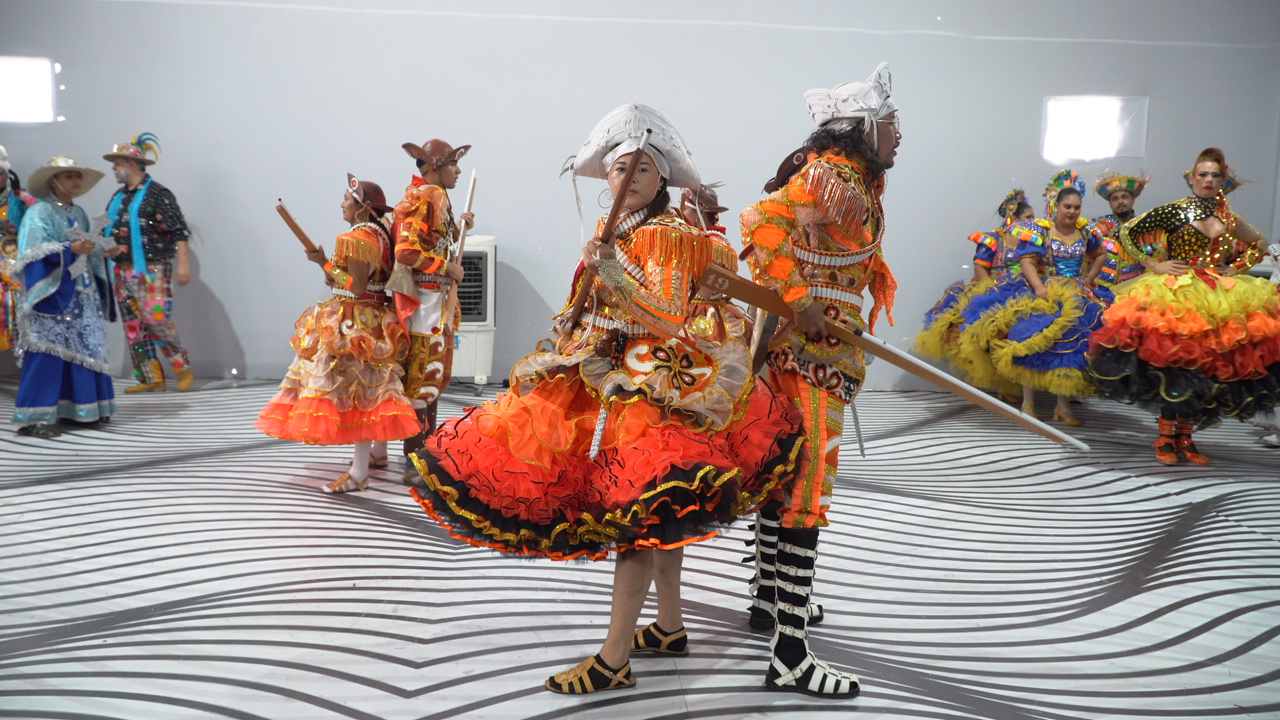 Artistas com trajes tradicionais em apresentação cultural
